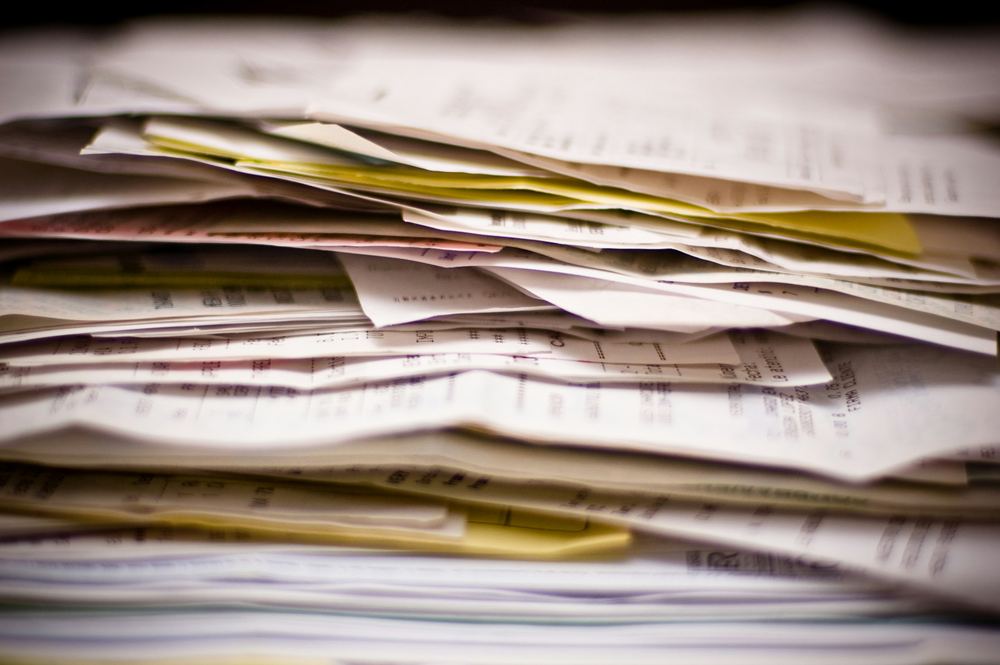 A thick stack of invoices and purchasing paperwork